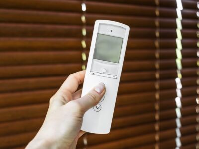 remote control for blinds. female hand holds and directs a remot